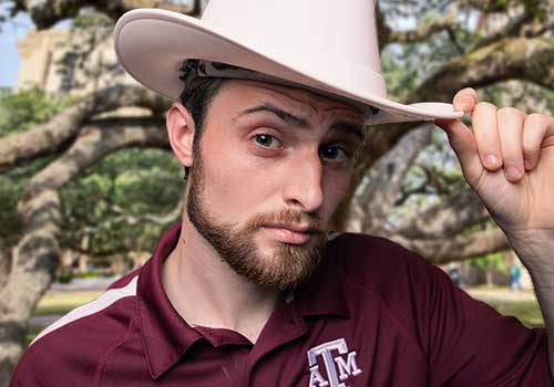 Howdy Crew tour member tips his cowboy hat toward the camera.